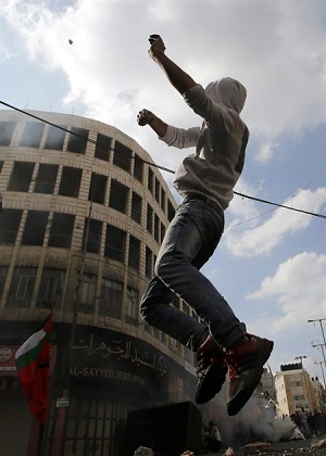 Jovem palestino atira pedras contra exército israelense| Foto: Efe