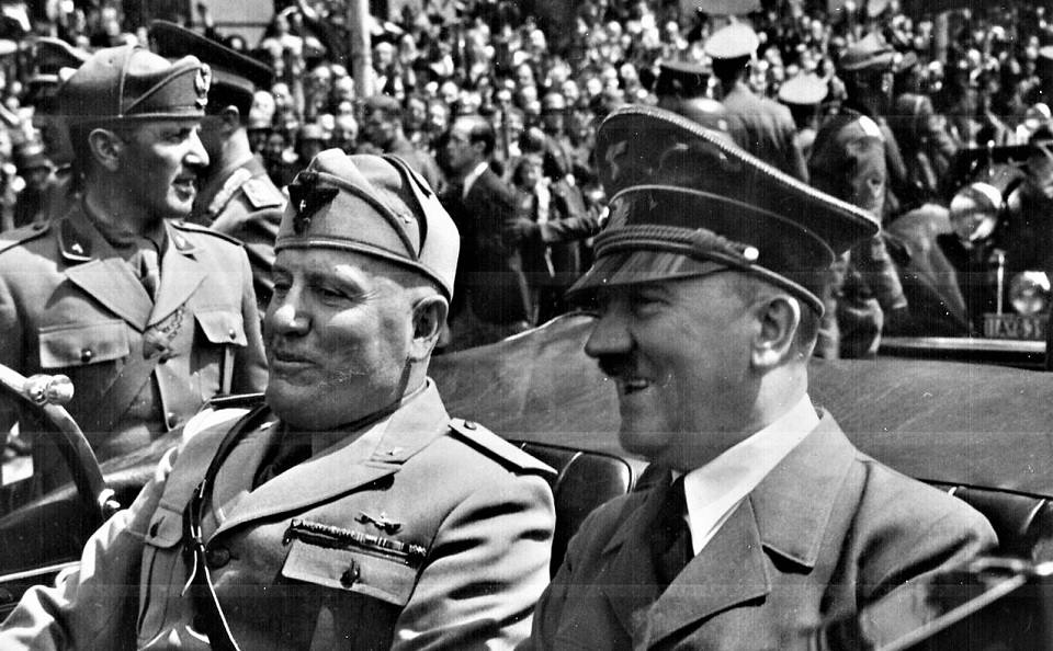 O líder fascista italiano Benito Mussolini no banco de trás de um veículo, acompanhado pelo líder nazista alemão Adolf Hitler, em Munique, 1940