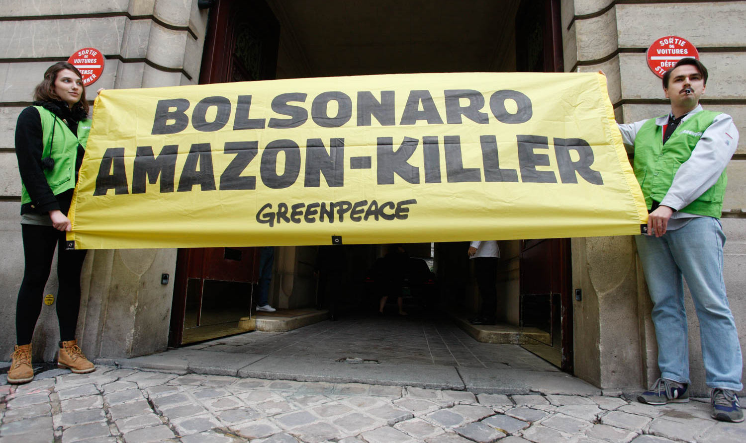 Manifestantes seguraram uma faixa com a mensagem 'Bolsonaro - assassino da Amazônia'; além de soarem cem alarmes no pátio da residência do embaixador brasileiro em Paris