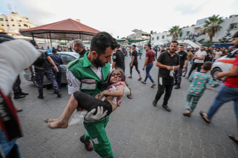 Medics transport an injured Palestinian child into Al-Shifa hospital in Gaza City
